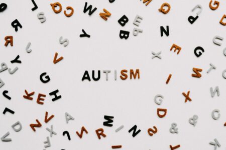 White background with mulitcoloured felt letters. In the centre the letters spell the word 'autism'