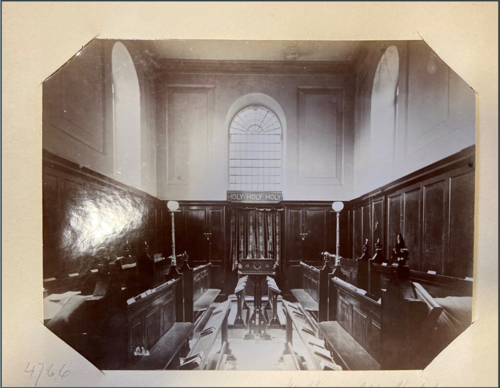 Black and white picture of interior of original Hertford Chapel, looking towards the altar with choir benches on either side