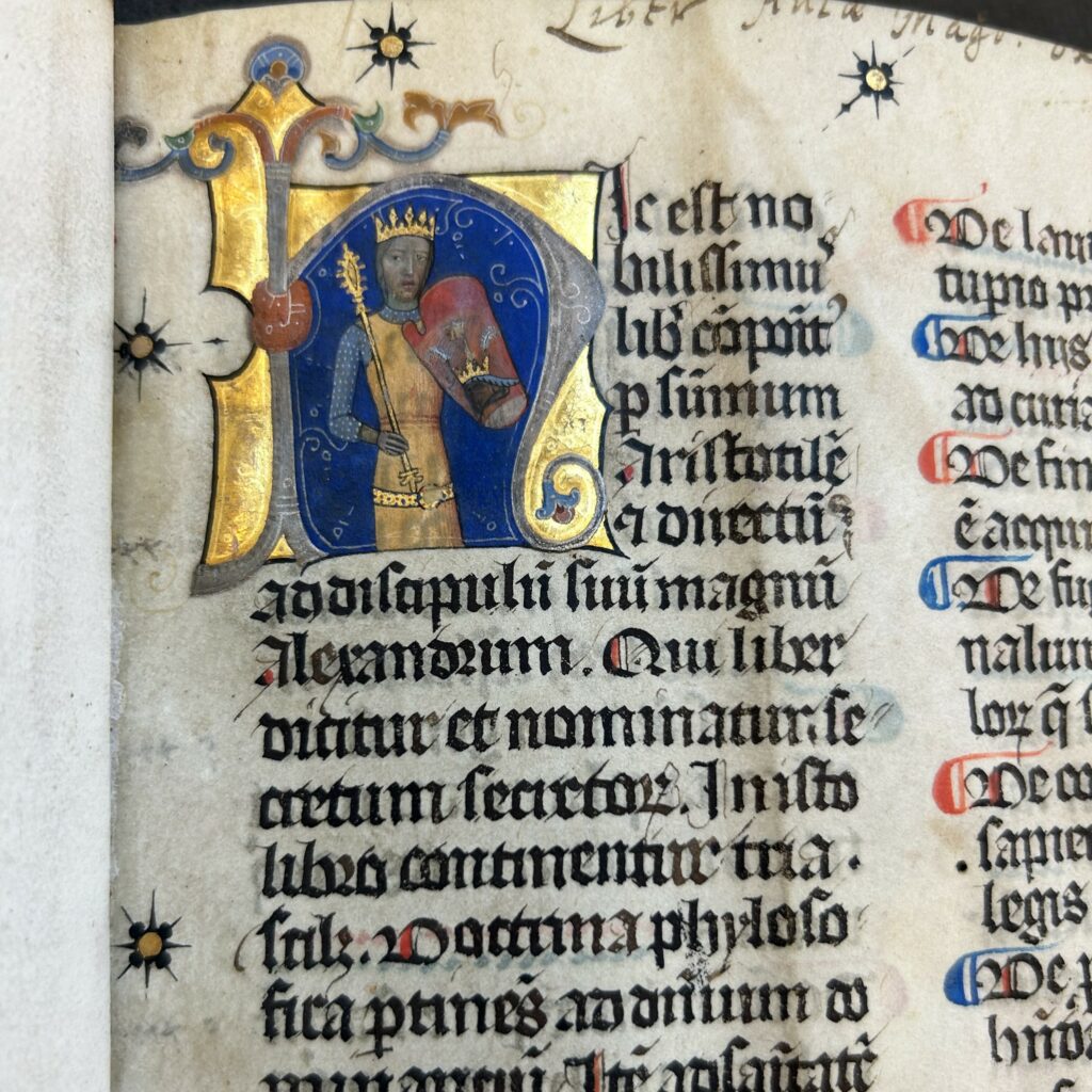 Close up of illuminated letter h, with King Louis dressed in chain mail and crown depicted within the letter. 