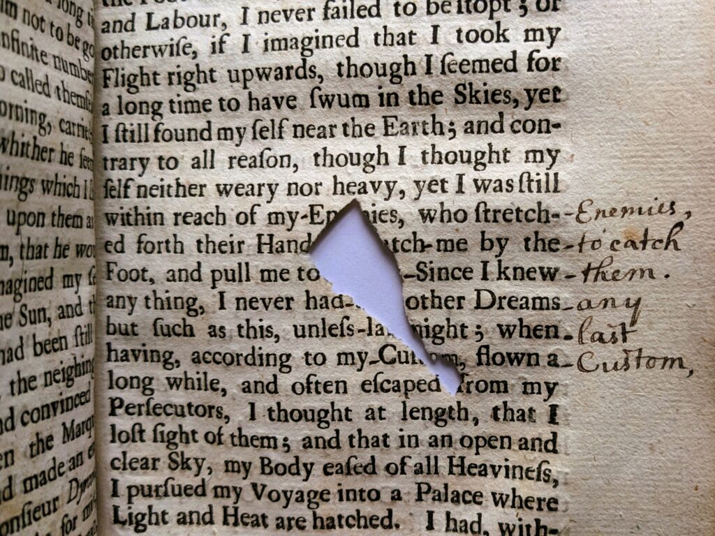 Close up of text with missing piece. Handwritten note in margin gives words for missing text.