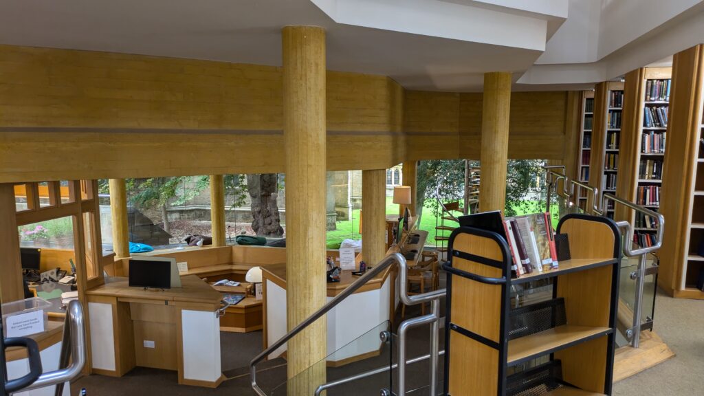 The front desk of Wadham's Library, with a column and handrail for steps in the foreground.